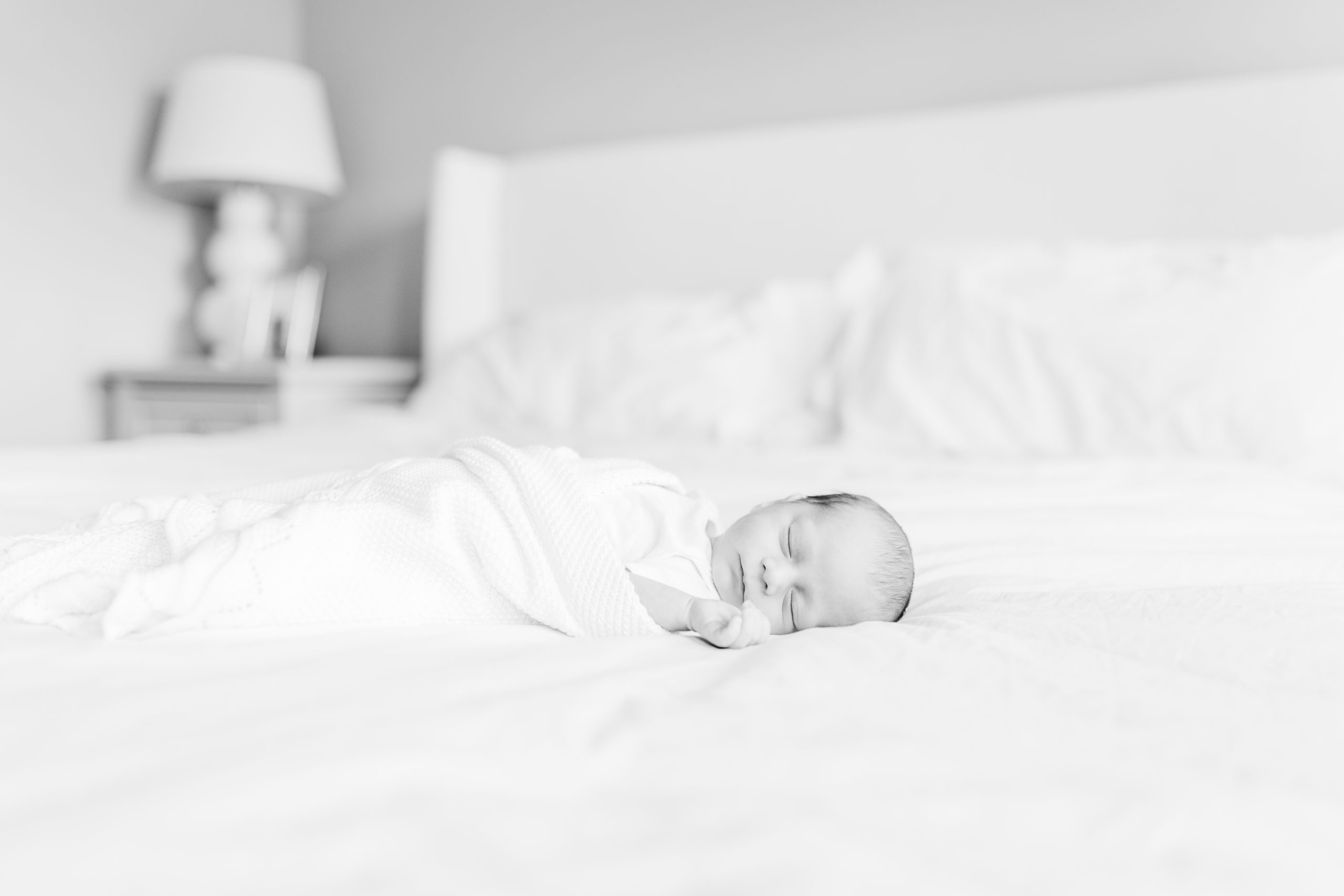 black and white portrait of a newborn baby asleep on a bed by Northern Virginia Newborn Photographer
