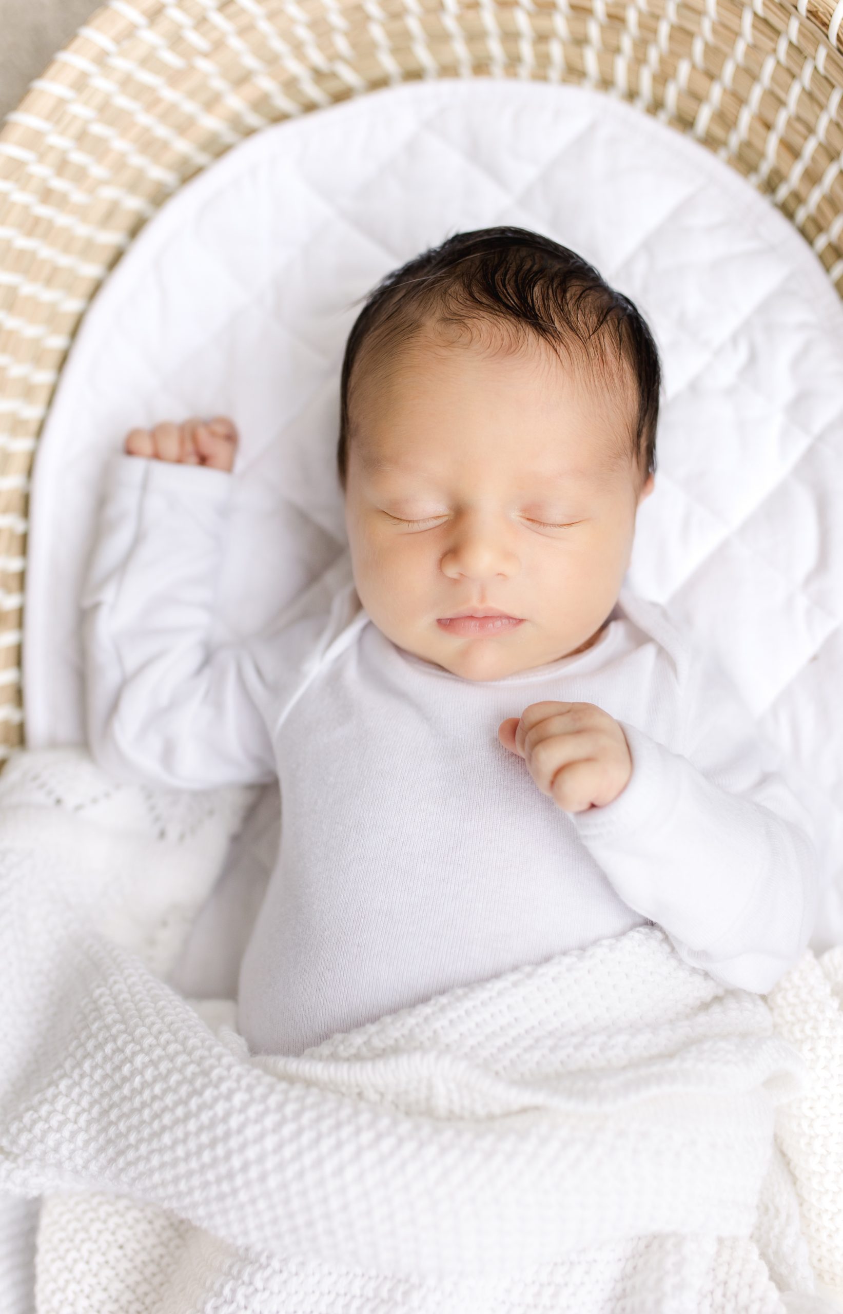 newborn baby asleep in a woven basket by DC newborn photographer