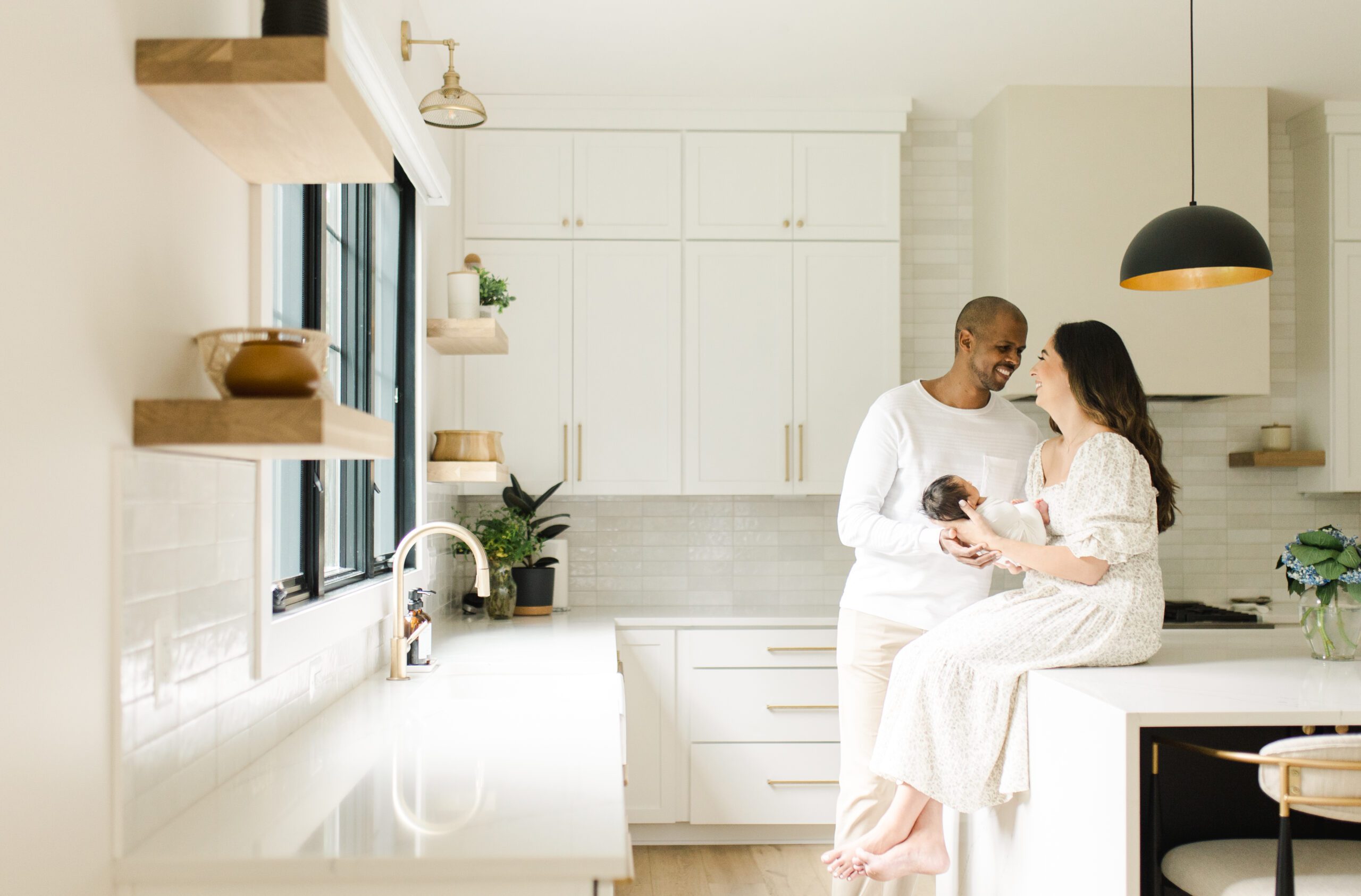 mom and dad in a gorgeous kitchen with newborn baby boy