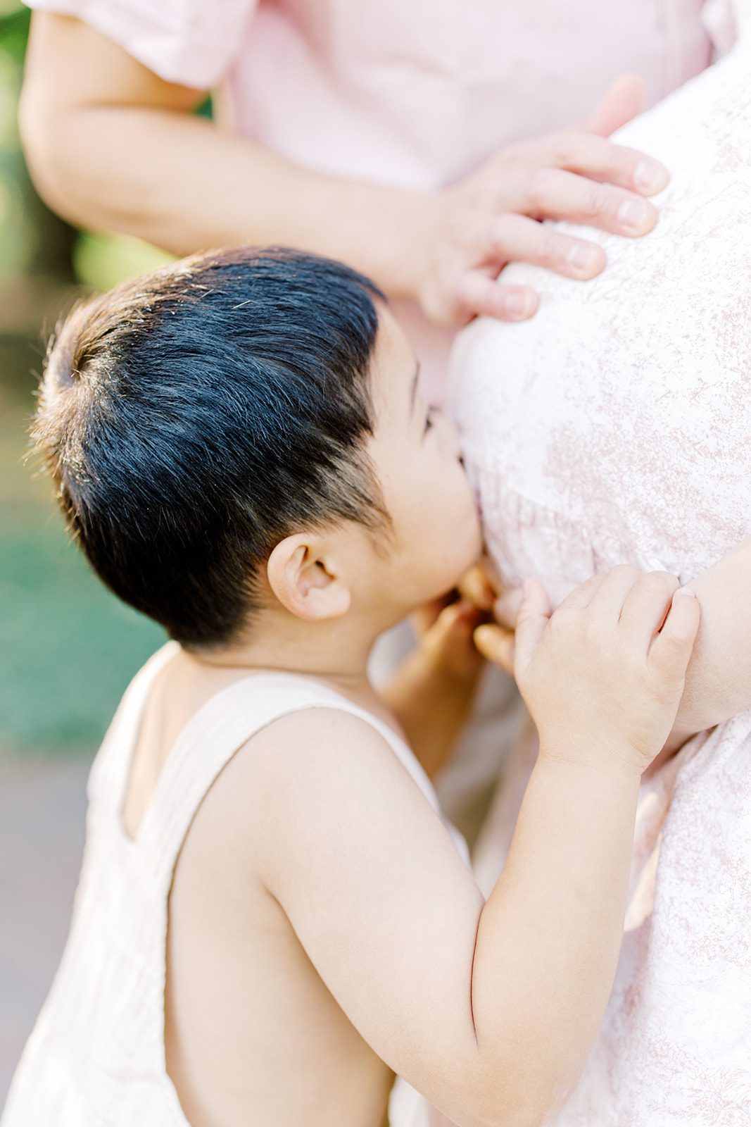 A toddler kisses mom's pregnant belly before visiting baby shower venues in DC